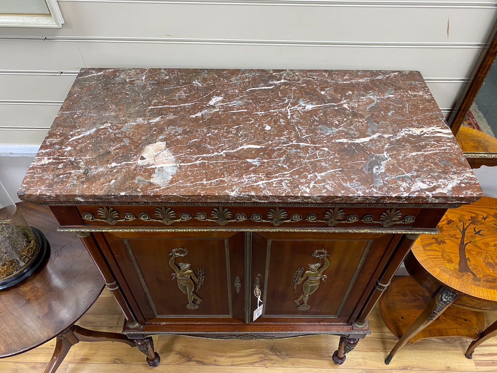 A French Empire style mahogany and gilt metal mounted marble topped side cabinet, width 89cm, depth 44cm, height 118cm